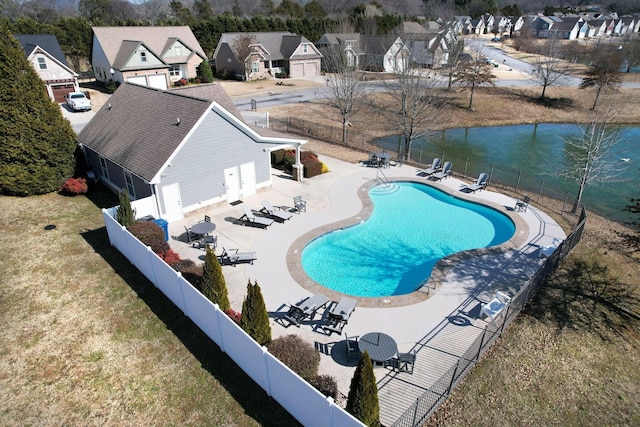 pool with fence, a patio, a water view, and a residential view