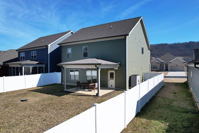 rear view of property with a fenced backyard, a patio area, a yard, and a residential view