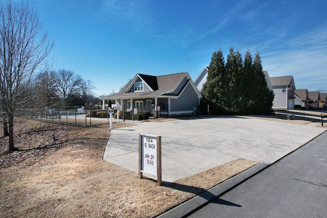 view of front of home with covered porch and fence