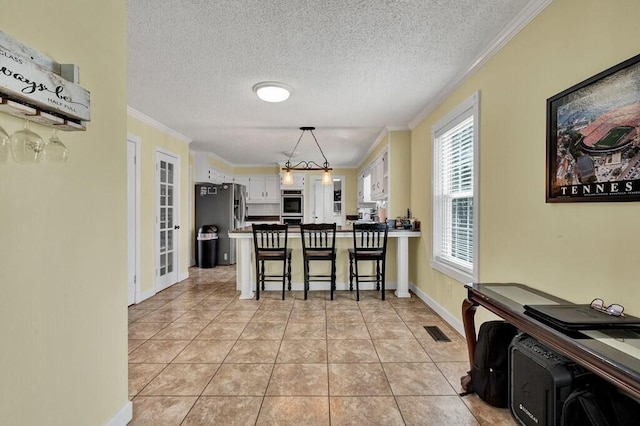 1922 W Brookhaven Cir, Dalton, GA 30720 - dining space with a textured ceiling, visible vents, light tile patterned floors, baseboards, and ornamental molding
