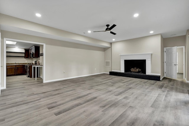 3839 Cleveland Hwy, Dalton, GA 30721 - unfurnished living room featuring a ceiling fan, light wood finished floors, a fireplace with raised hearth, baseboards, and recessed lighting