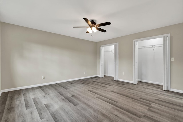 3839 Cleveland Hwy, Dalton, GA 30721 - unfurnished bedroom with two closets, baseboards, wood finished floors, and ceiling fan