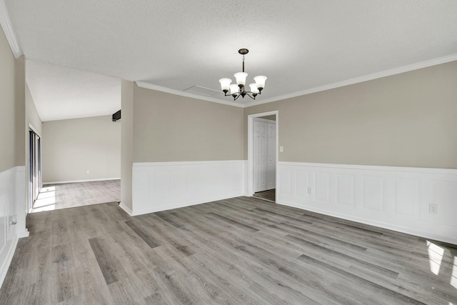 3839 Cleveland Hwy, Dalton, GA 30721 - unfurnished dining area with a chandelier, wood finished floors, a wainscoted wall, ornamental molding, and a textured ceiling