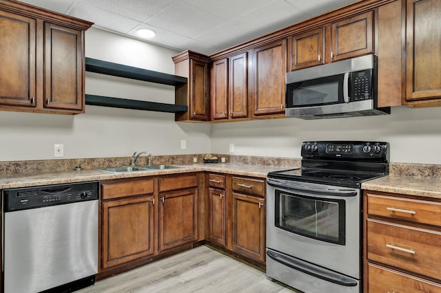 3839 Cleveland Hwy, Dalton, GA 30721 - kitchen featuring stainless steel appliances, a sink, open shelves, light wood-style floors, and light countertops