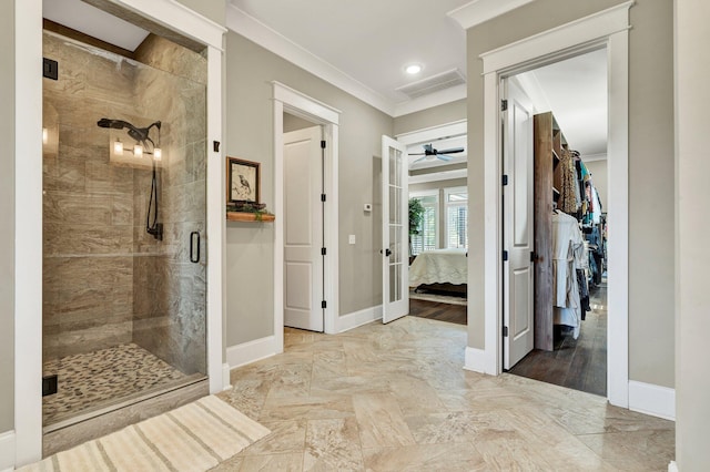 ensuite bathroom with visible vents, ornamental molding, baseboards, a shower stall, and a ceiling fan