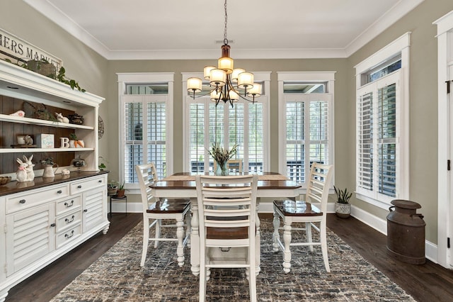 dining area featuring crown molding, baseboards, dark wood-type flooring, and a chandelier