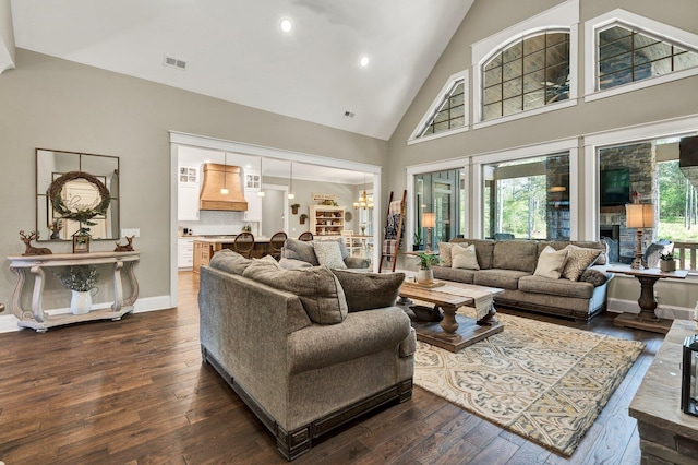 living area featuring dark wood-style flooring, visible vents, high vaulted ceiling, a chandelier, and recessed lighting