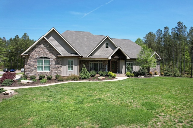 craftsman house with board and batten siding, stone siding, and a front yard