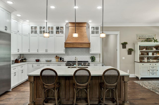 kitchen featuring a sink, backsplash, custom exhaust hood, and stainless steel built in refrigerator