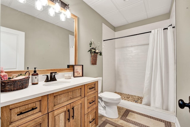 full bath featuring vanity, a tile shower, and toilet