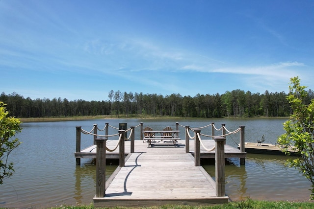 dock area featuring a forest view and a water view