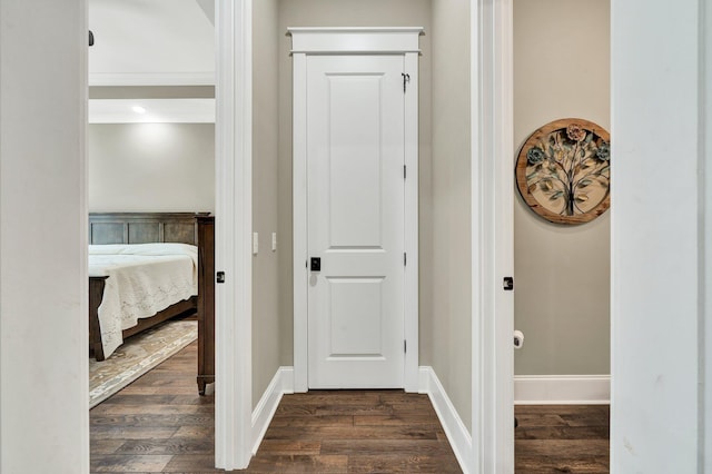 hall featuring baseboards and dark wood-style flooring