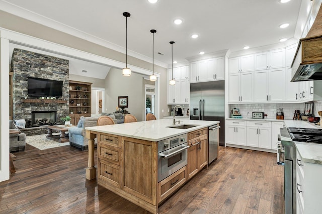 kitchen featuring a sink, appliances with stainless steel finishes, white cabinetry, and open floor plan