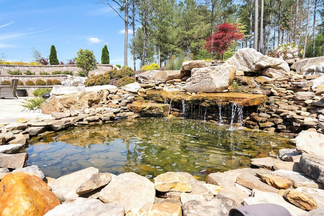 exterior details with a garden pond
