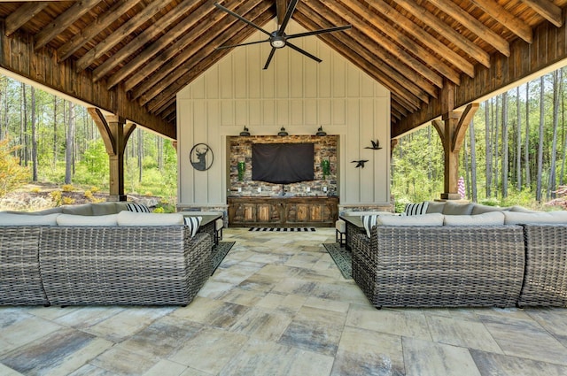 view of patio / terrace featuring ceiling fan and an outdoor living space with a fireplace