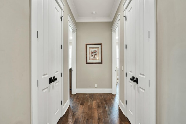 foyer featuring crown molding, dark wood-style flooring, and baseboards
