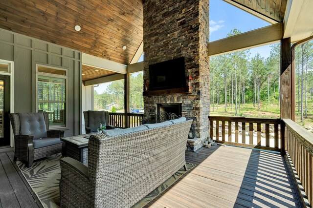 wooden deck with an outdoor living space with a fireplace