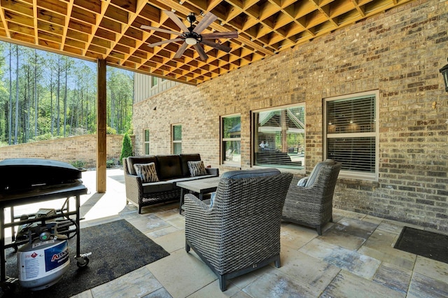 view of patio with an outdoor living space, a ceiling fan, fence, and a grill