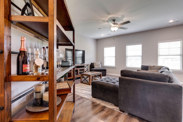 living area featuring baseboards, a ceiling fan, recessed lighting, and wood finished floors