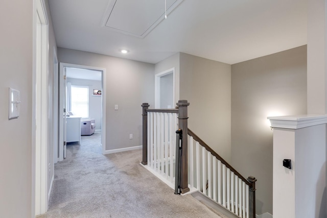 hallway featuring carpet flooring, attic access, recessed lighting, baseboards, and an upstairs landing