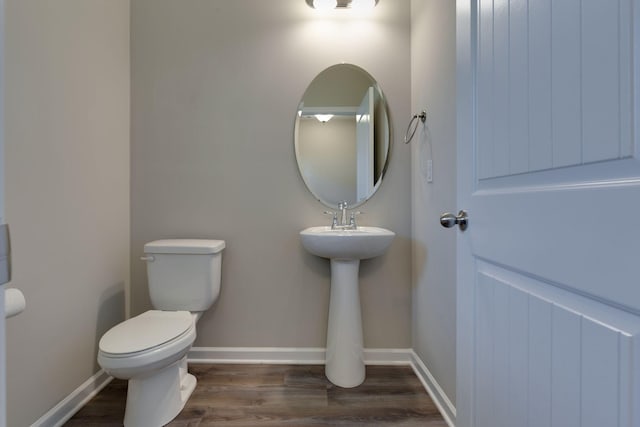 bathroom featuring toilet, baseboards, and wood finished floors