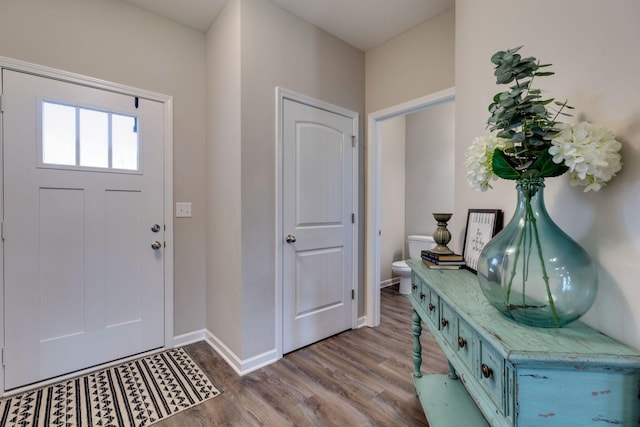 foyer entrance with baseboards and wood finished floors