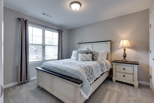 bedroom featuring visible vents, baseboards, and light colored carpet