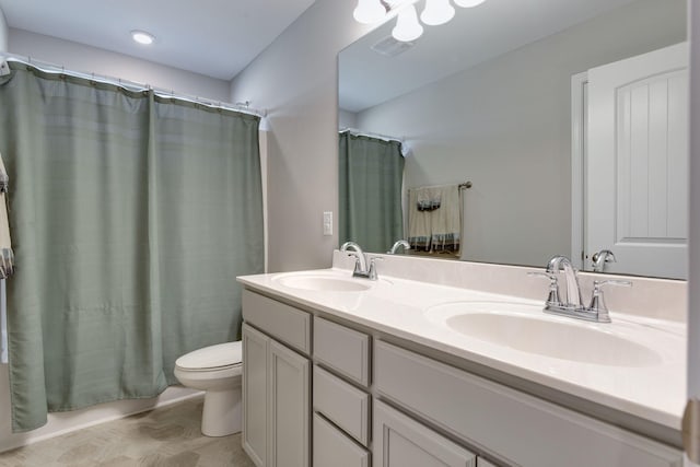 bathroom with double vanity, toilet, a sink, and shower / bath combo with shower curtain
