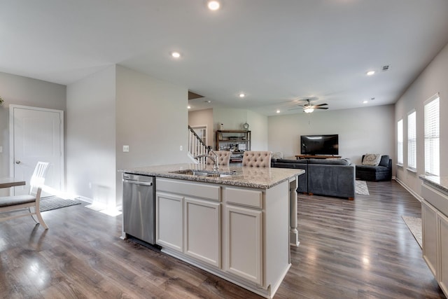 kitchen with ceiling fan, dark wood-style flooring, a center island with sink, dishwasher, and a sink