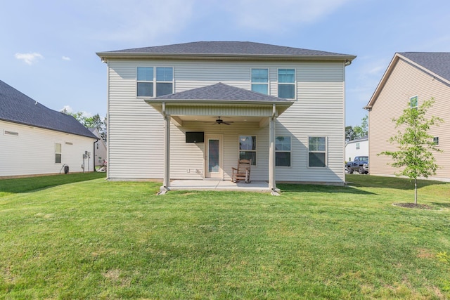 rear view of property featuring a yard, a ceiling fan, and a patio area