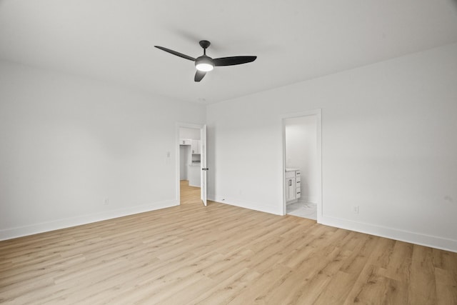 unfurnished bedroom with connected bathroom, a ceiling fan, baseboards, and light wood-style flooring