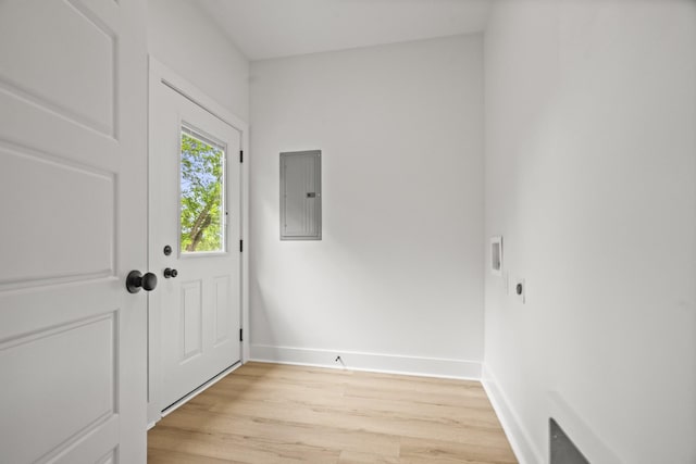 doorway to outside with baseboards, light wood finished floors, and electric panel