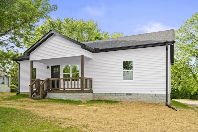back of property featuring a yard, crawl space, a porch, and roof with shingles
