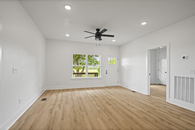 unfurnished living room with a ceiling fan, baseboards, visible vents, and light wood-style flooring