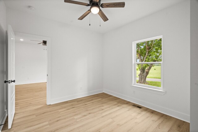 spare room with a ceiling fan, visible vents, plenty of natural light, and light wood-style flooring