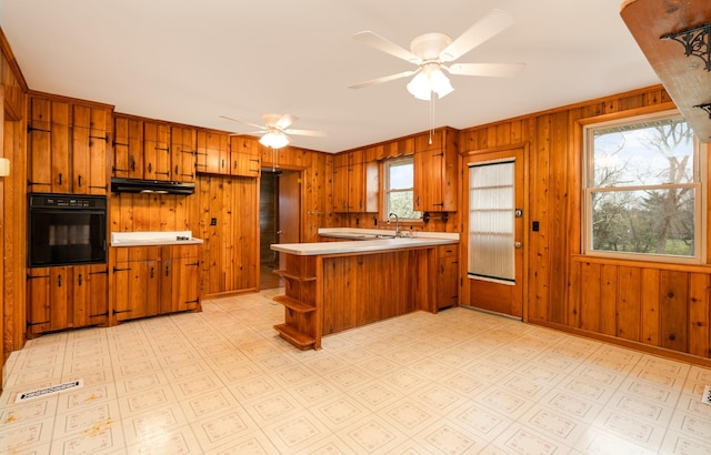 905 Crownhill Dr, Nashville, TN 37217 - kitchen featuring brown cabinetry, black oven, a peninsula, and under cabinet range hood