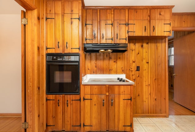 905 Crownhill Dr, Nashville, TN 37217 - kitchen featuring under cabinet range hood, brown cabinets, black appliances, and light wood-type flooring