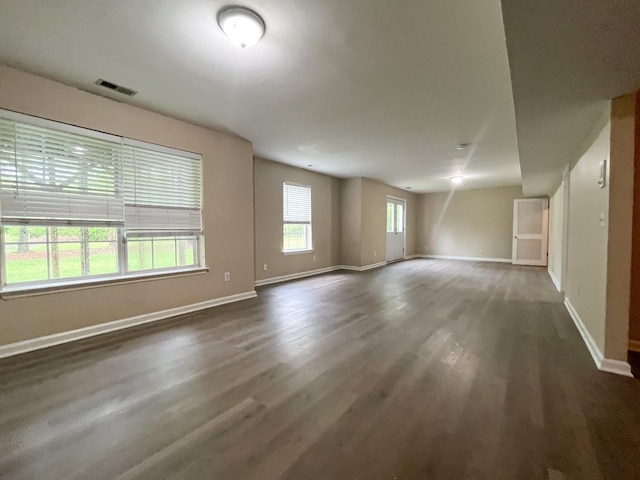 interior space with baseboards, wood finished floors, and visible vents