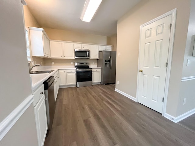 kitchen featuring a sink, appliances with stainless steel finishes, dark wood-style floors, and white cabinetry