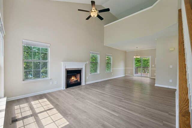 2300 Devonshire Dr, Old Hickory, TN 37138 - unfurnished living room featuring high vaulted ceiling, a lit fireplace, a chandelier, plenty of natural light, and light wood-type flooring