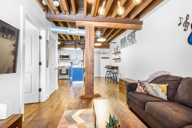 610 21st Ave N Unit 302, Nashville, TN 37203 - living room with beam ceiling, light wood-style flooring, and visible vents