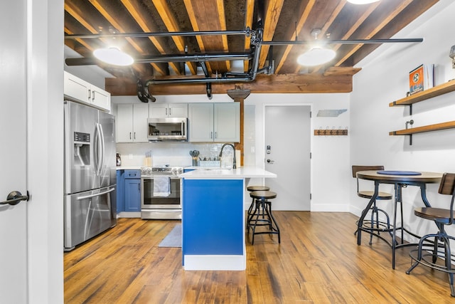 610 21st Ave N Unit 302, Nashville, TN 37203 - kitchen featuring a peninsula, a breakfast bar area, light countertops, a sink, and appliances with stainless steel finishes