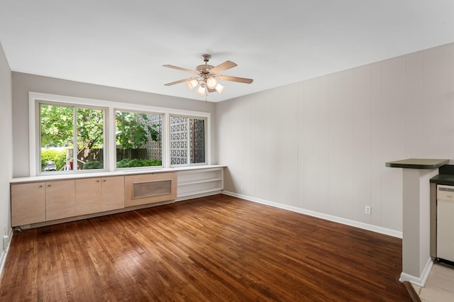 unfurnished living room featuring baseboards, a ceiling fan, and wood finished floors