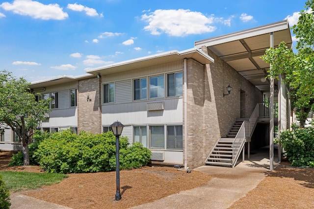 view of front of house featuring stairway and brick siding