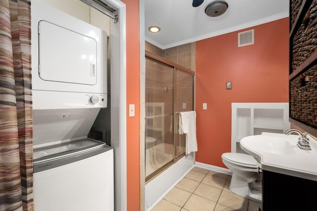 full bathroom with visible vents, tile patterned flooring, stacked washing maching and dryer, toilet, and ornamental molding