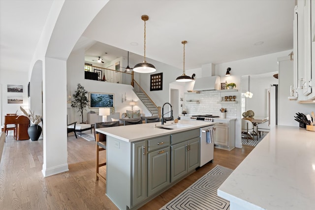 5960 Lickton Pike, Goodlettsville, TN 37072 - kitchen featuring open shelves, a sink, arched walkways, light wood-style flooring, and stainless steel dishwasher