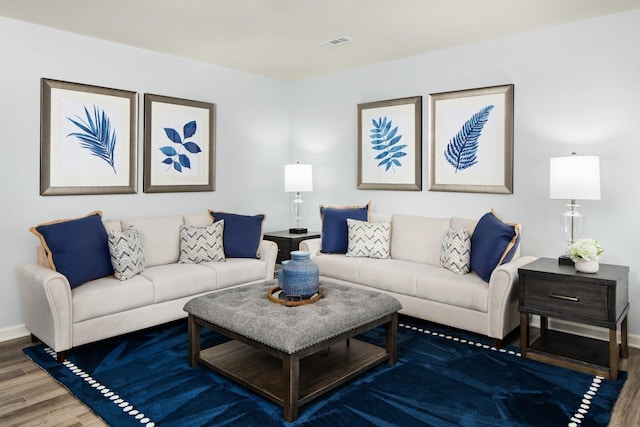 living area featuring baseboards, wood finished floors, and visible vents