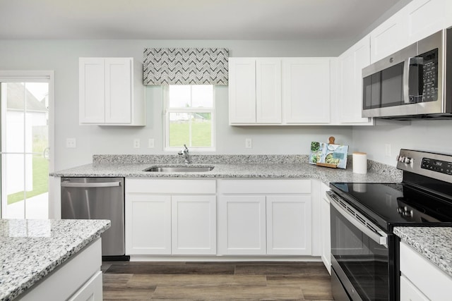 kitchen featuring white cabinets, stainless steel appliances, dark wood-style floors, and a sink
