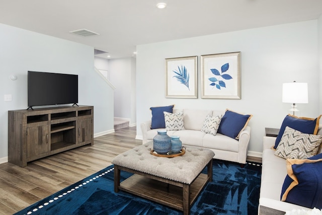 living area with visible vents, wood finished floors, recessed lighting, baseboards, and stairs