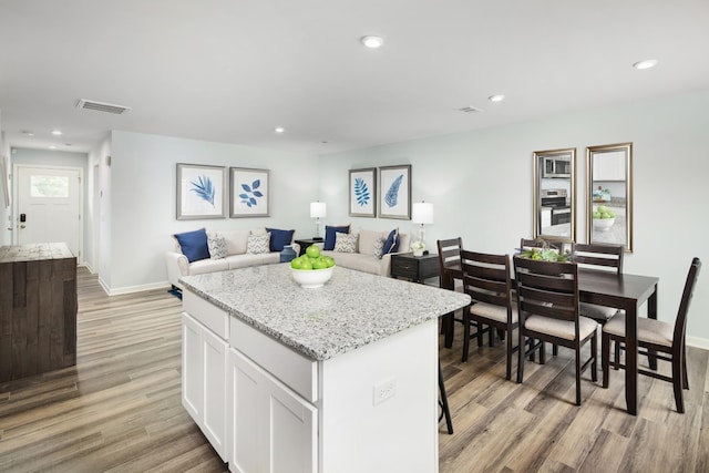 kitchen with visible vents, recessed lighting, light wood-style floors, and a center island